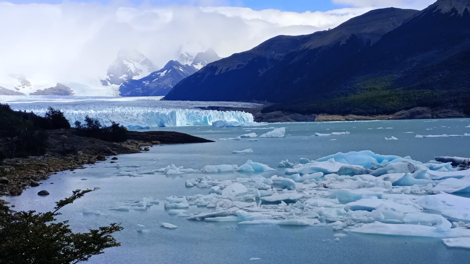 Una gran masa de agua rodeada de montañas y hielo.