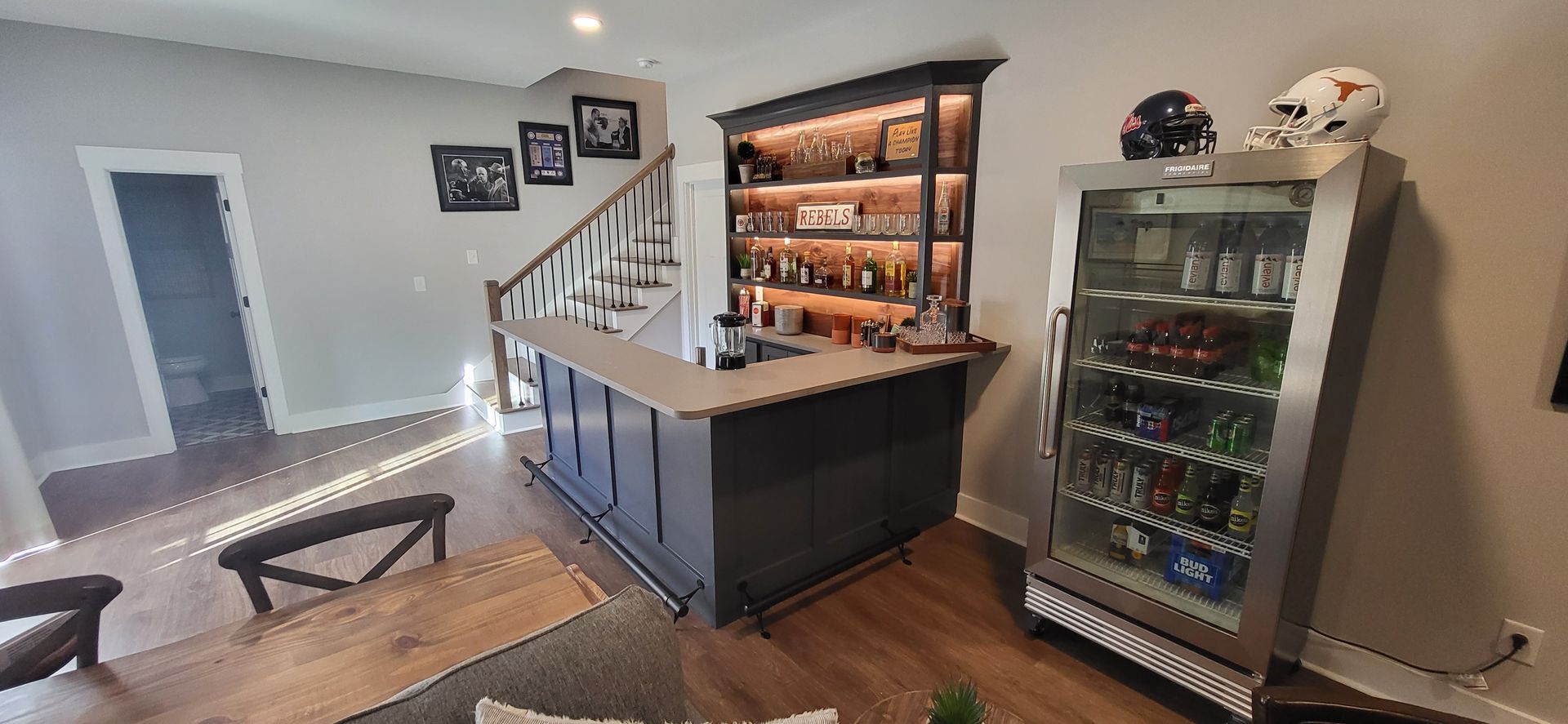 A living room with a bar and a refrigerator.