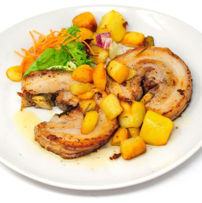 Un piatto di pancetta di maiale arrosto arrotolata, servito con patate arrosto dorate e un contorno di carote e verdure a foglia verde grattugiate.