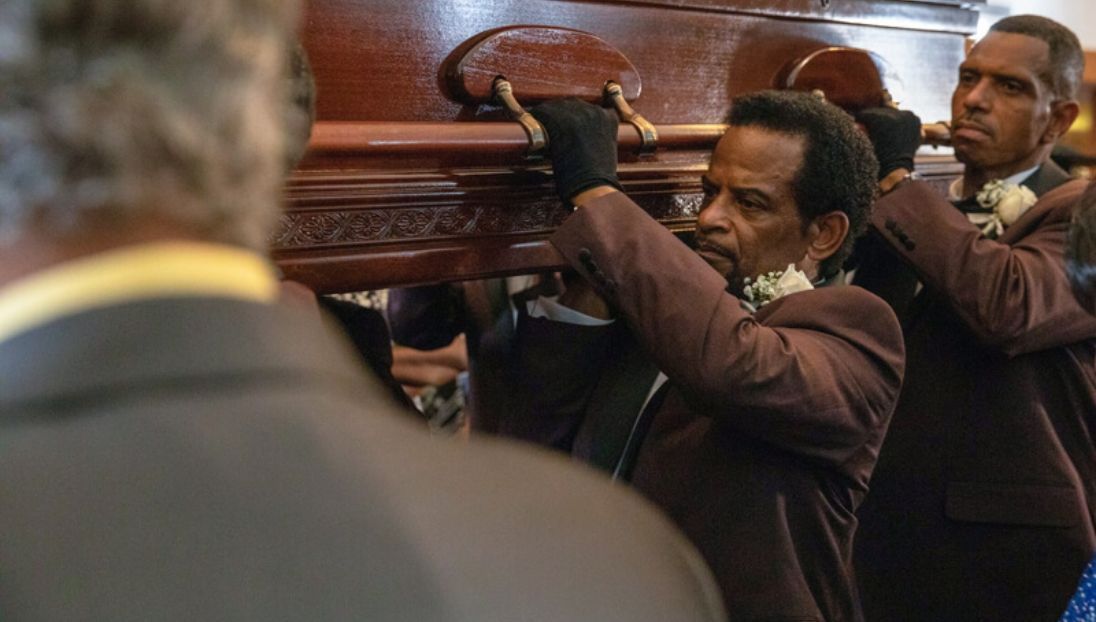 pipkin staff holding carrying casket on their shoulders