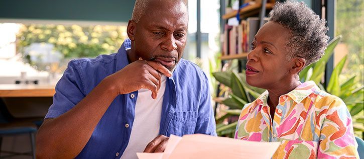 Black couple reviewing insurance policy papers for funeral preplanning