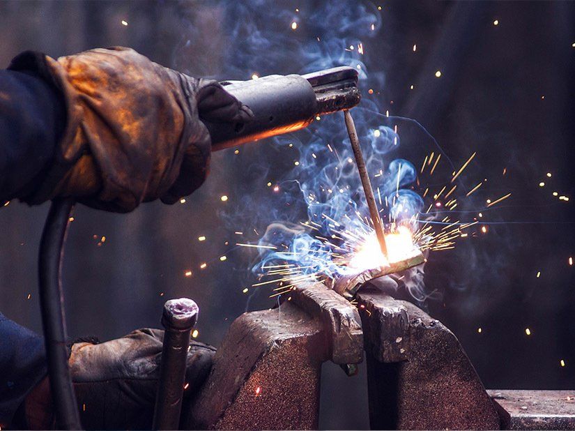 Industry Worker Welding Iron Pieces —  Metal Fabrication & Welding in Garbutt, QLD