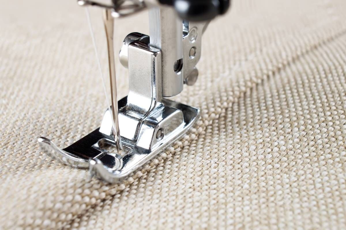 A detailed image of a sewing machine needle stitching a soft window treatment project