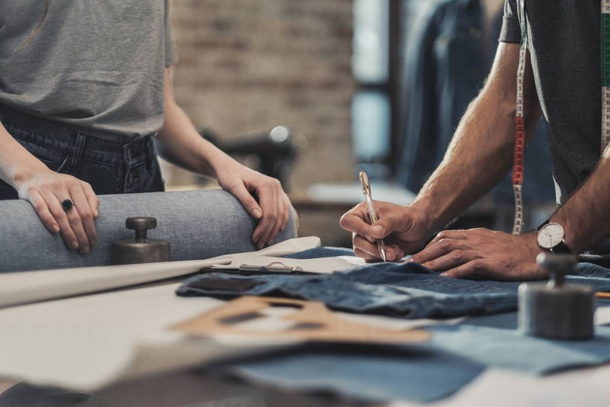 An image of sewists collaborating in the custom drapery workroom on fabrics and measurements