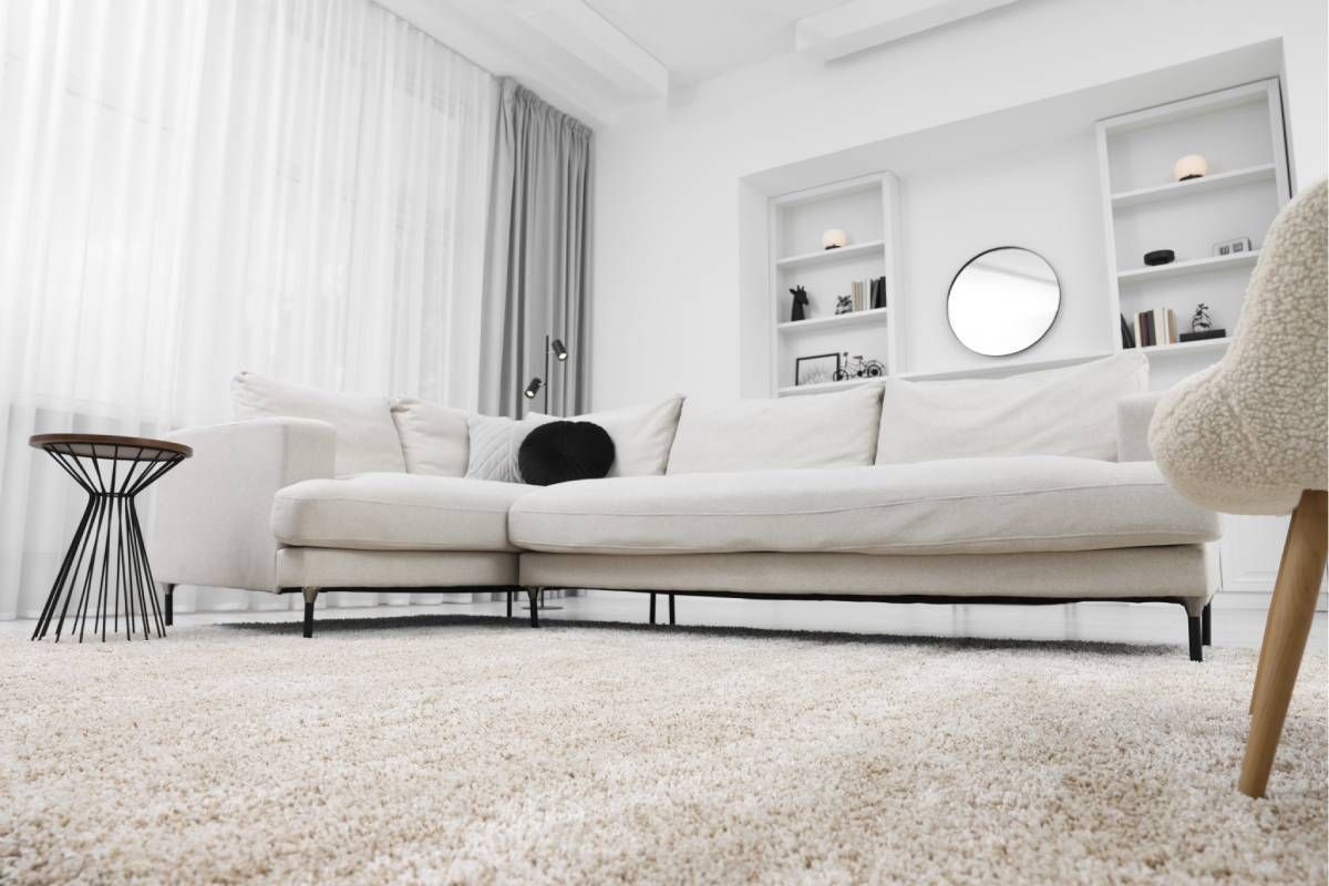 Modern living room with white walls, area rug, and side table