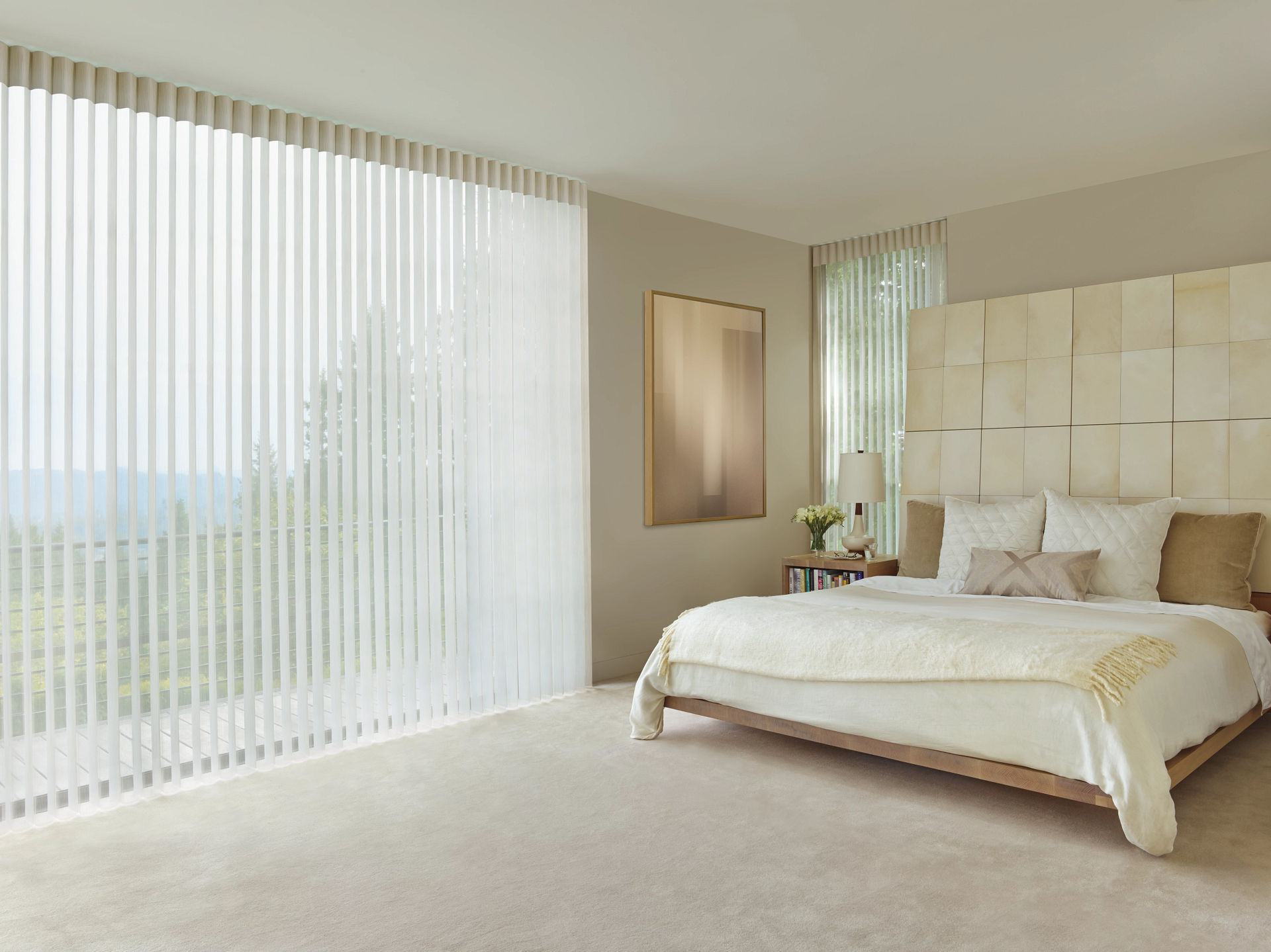 Sheer, light-toned Luminette® Sheer Panels on an expansive window, coordinated with bedroom carpet for lux style