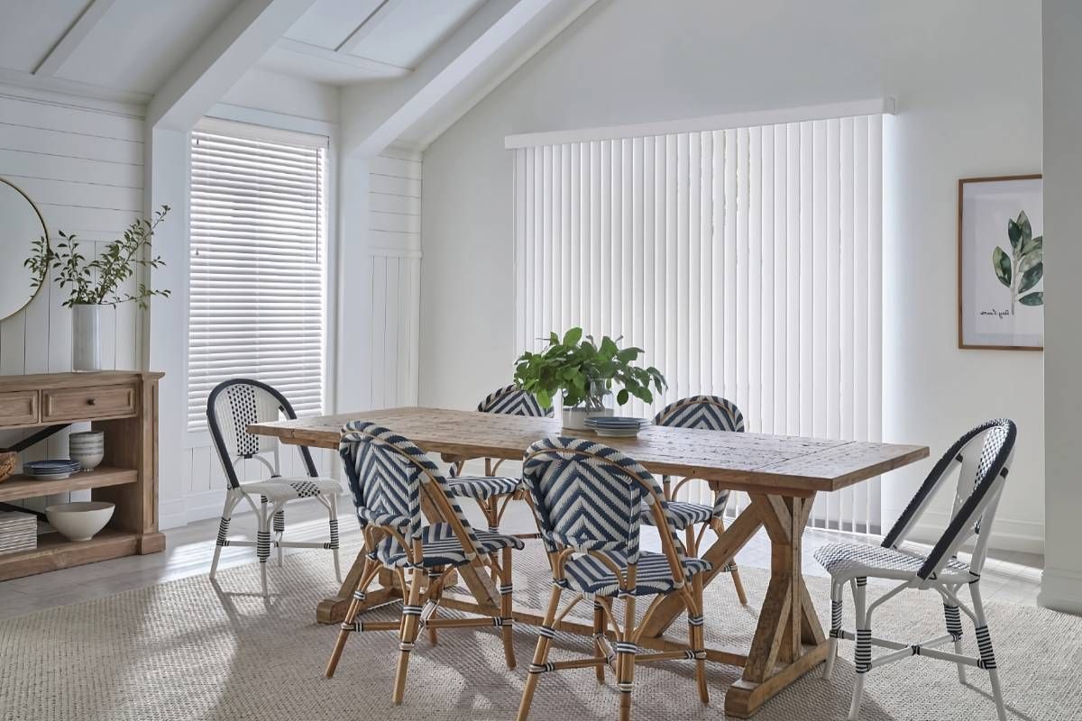 Sleek and chic Hunter Douglas Vertical Solutions® Vertical Blinds on a dining room's sliding door at Maple Drapery & Carpet