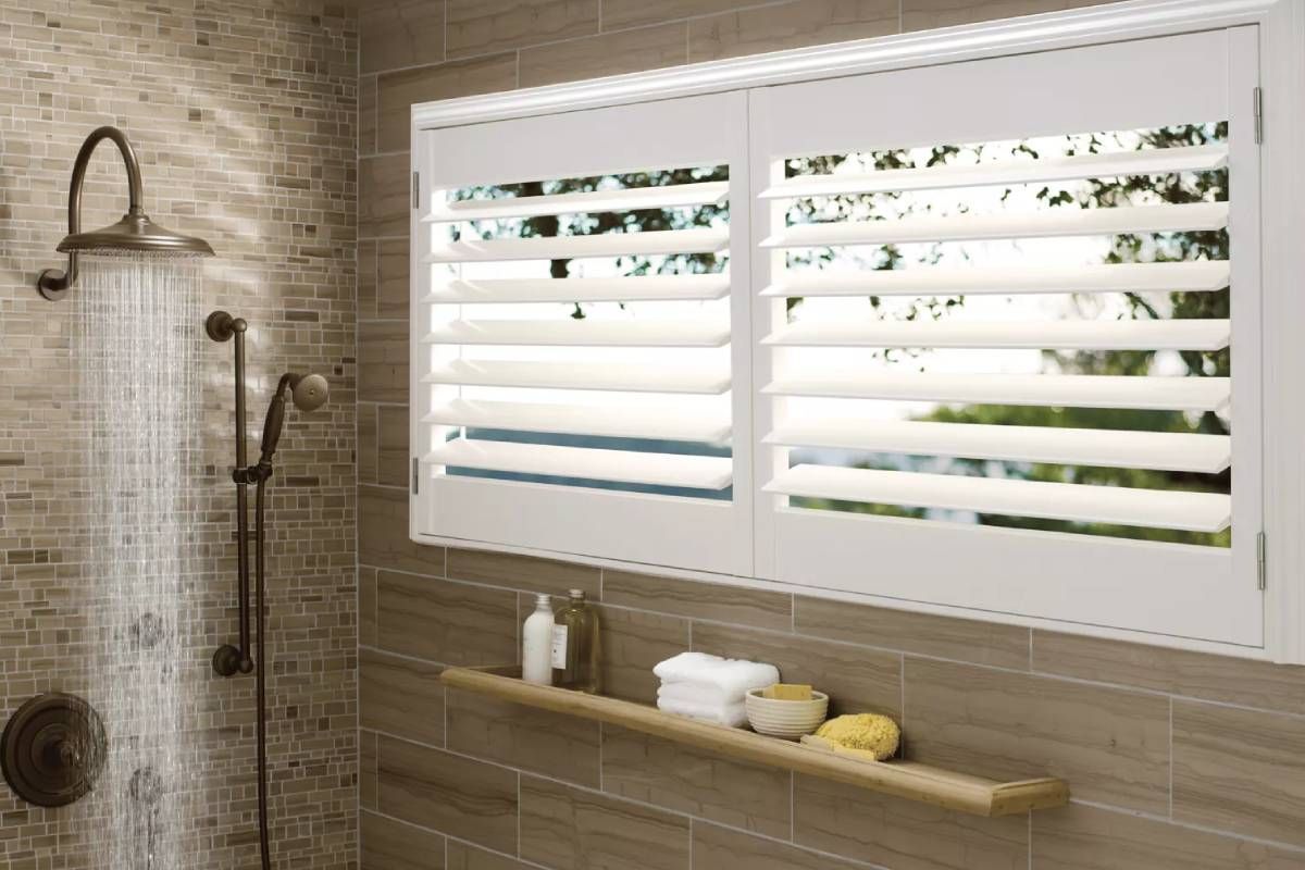 White Hunter Douglas Palm Beach™ Polysatin™ Vinyl Shutters in a Bathroom Window