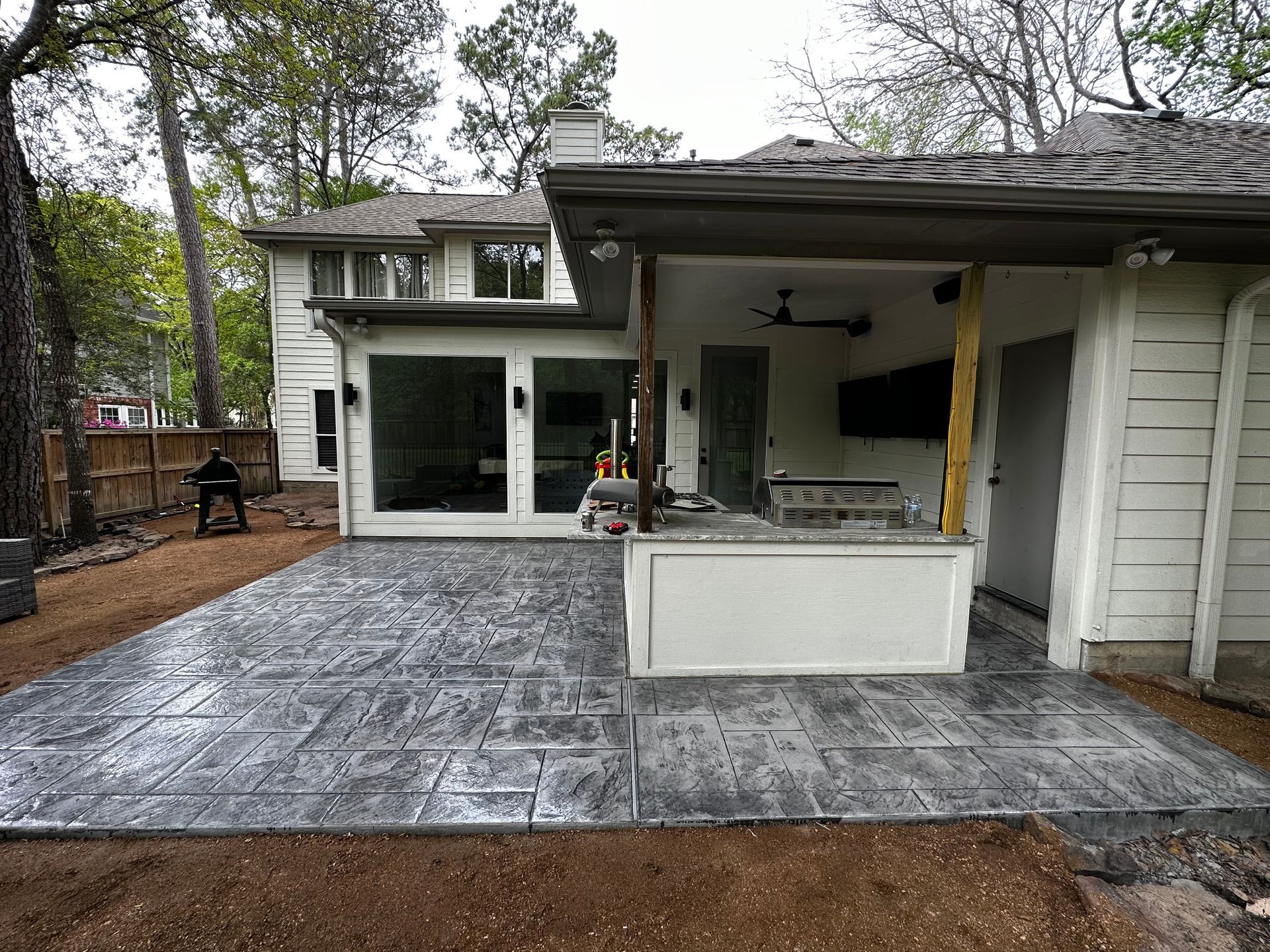 A patio with a kitchen in the backyard of a house.