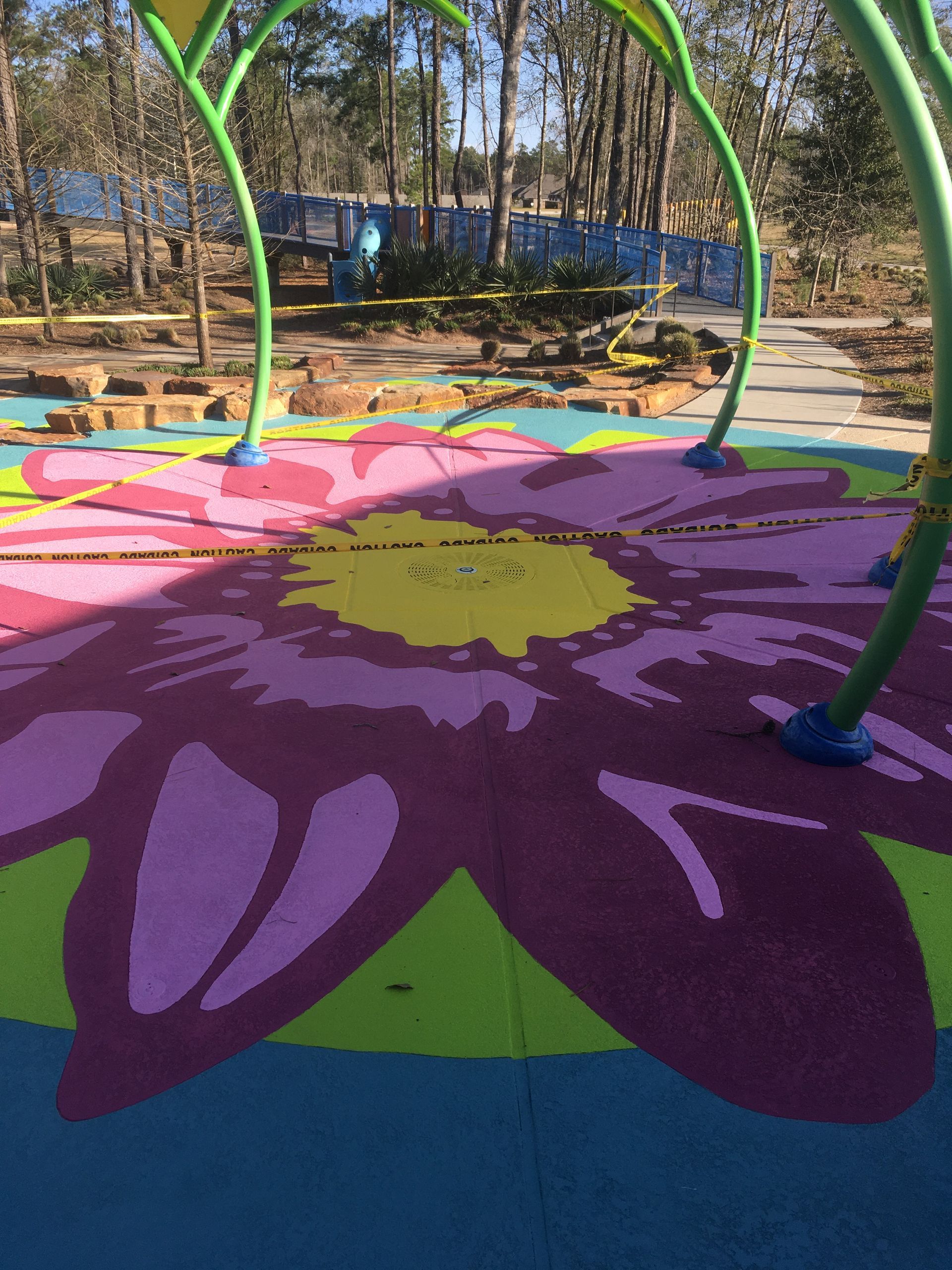 A colorful flower is painted on the floor of a playground
