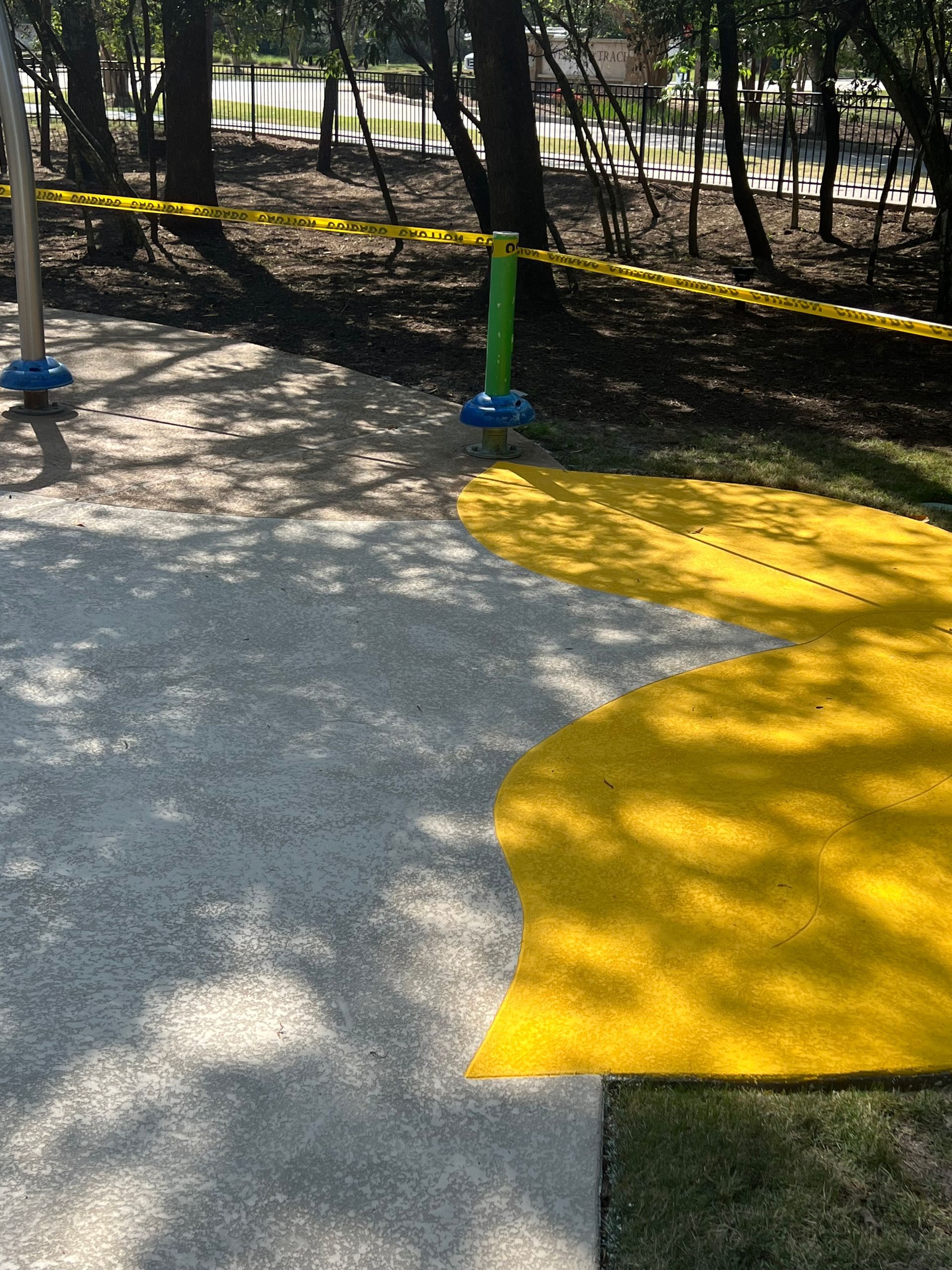 A concrete walkway with a yellow circle painted on it