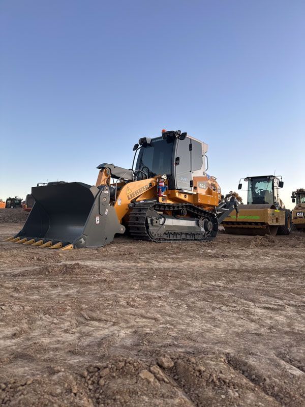 A bulldozer is parked in a dirt field.