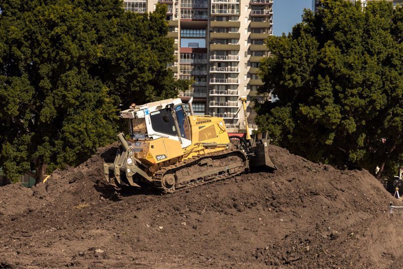A bulldozer is sitting on top of a pile of dirt.
