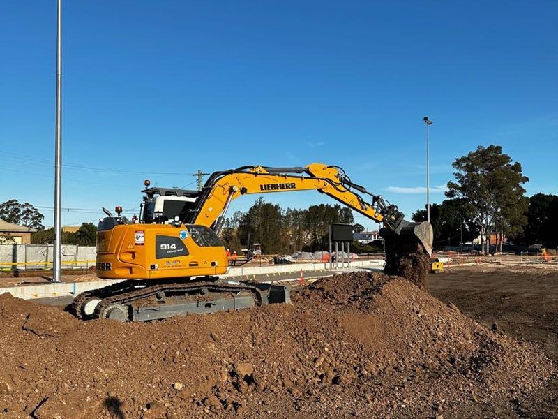A yellow excavator is moving dirt on a construction site.