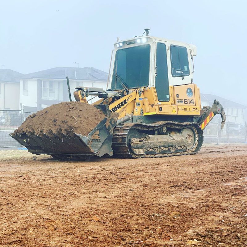 A yellow and white bulldozer with the number 614 on it