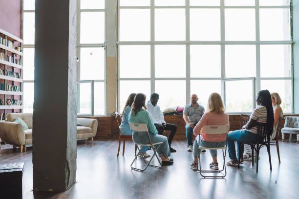 A group of people are sitting in a circle in a room.