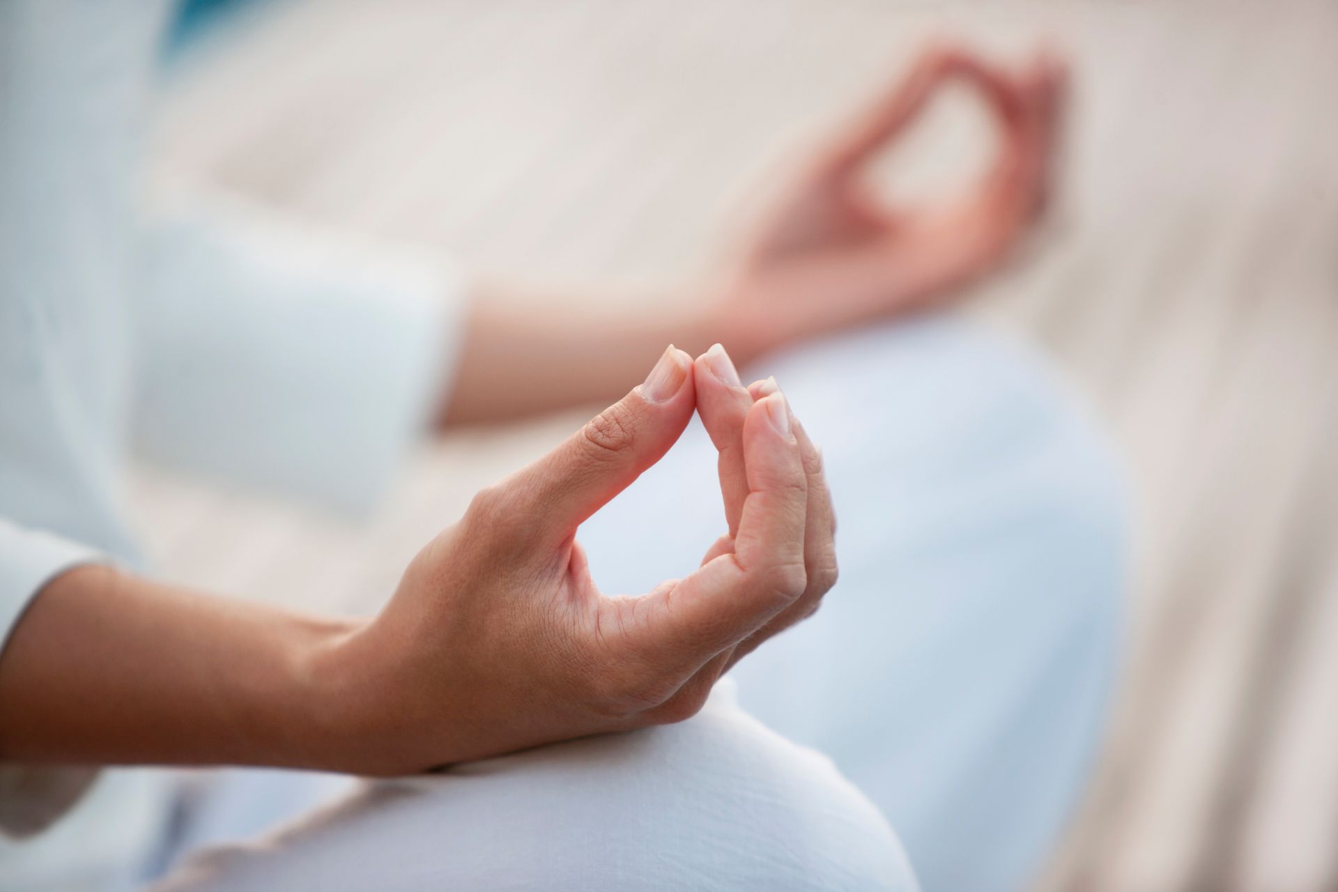 A close up of a person 's hands in a lotus position.