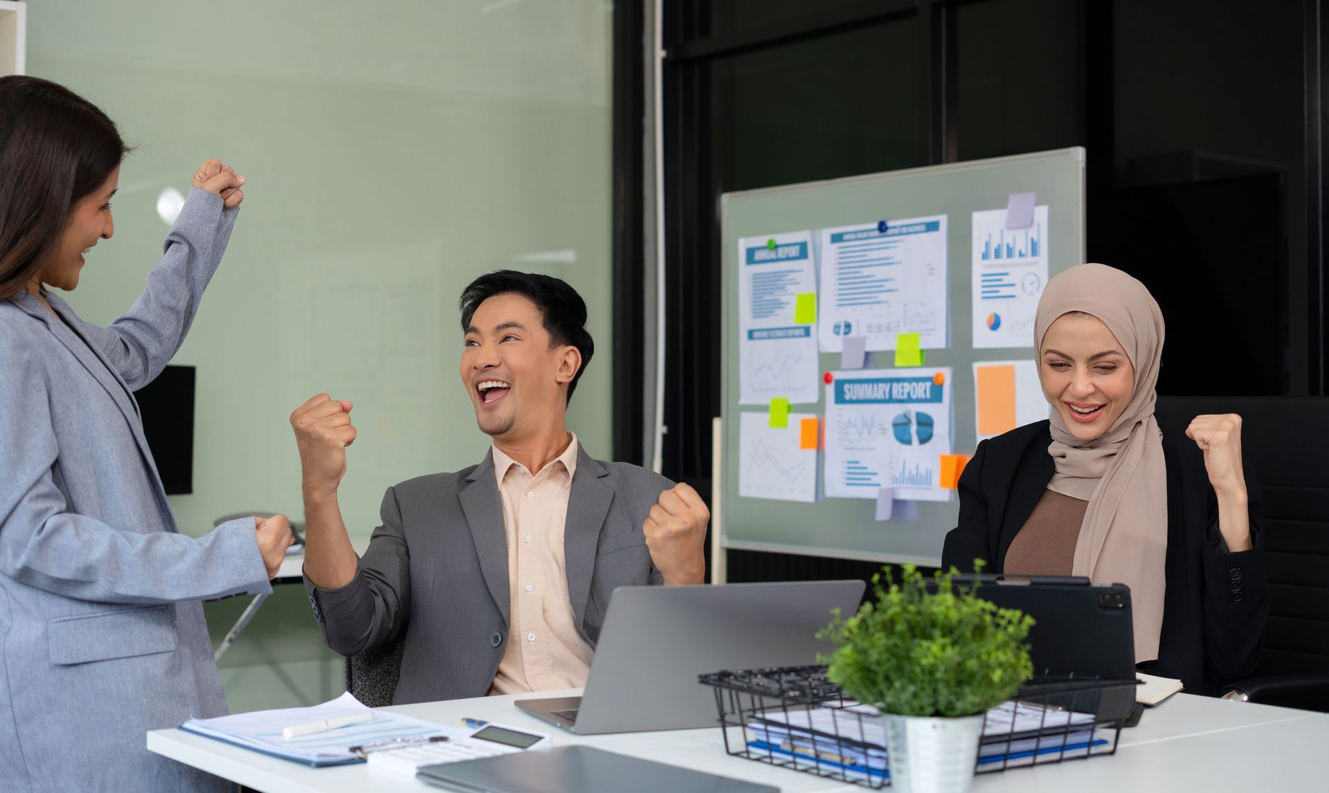 A group of business people are celebrating their success in an office.