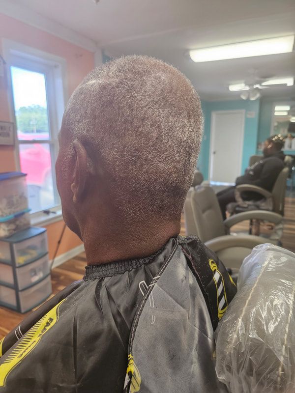A man is getting his hair cut in a salon.