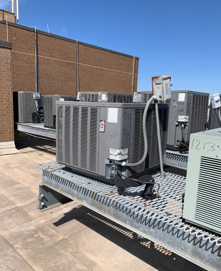 A bunch of air conditioners are sitting on top of a roof