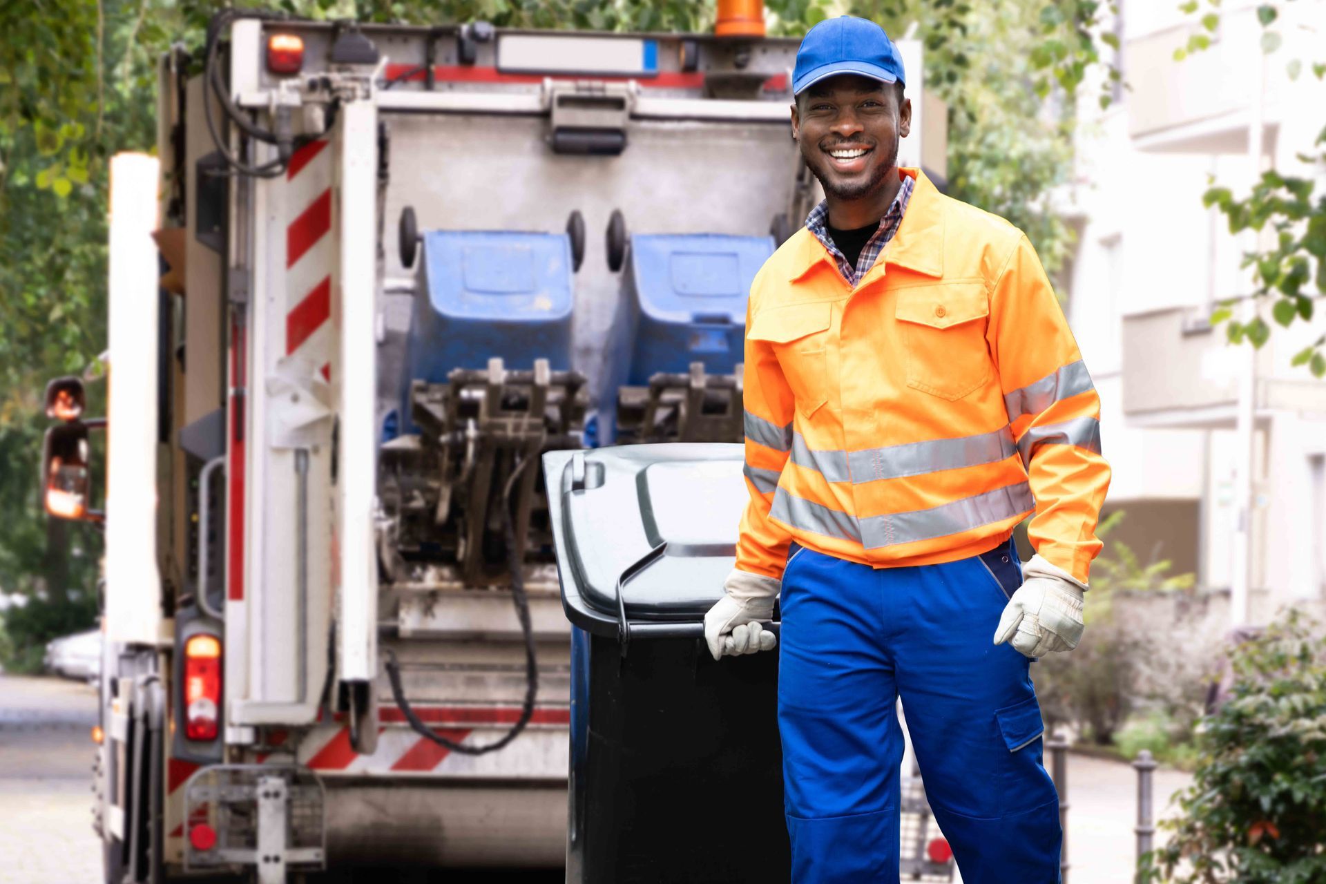 A worker rolling a trash bin toward a garbage truck during residential curbside pickup