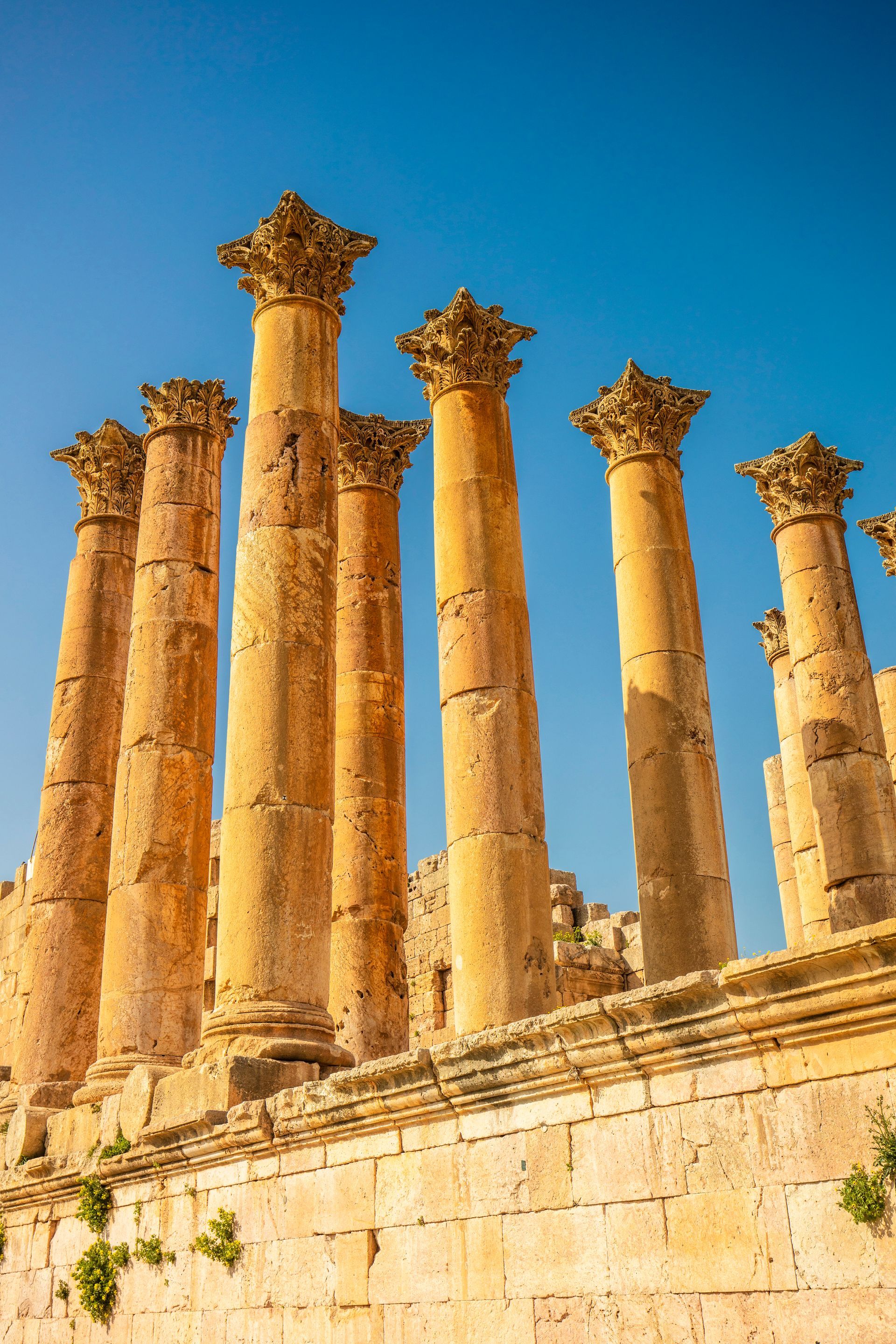A row of columns sitting next to each other on top of a stone wall.