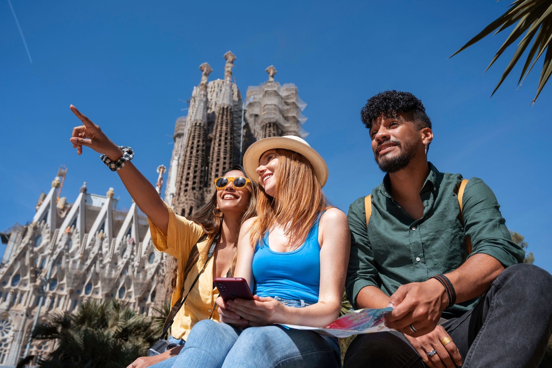 A group of people are sitting in front of a large building.