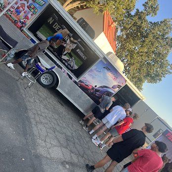 A group of people are standing in front of a food truck.