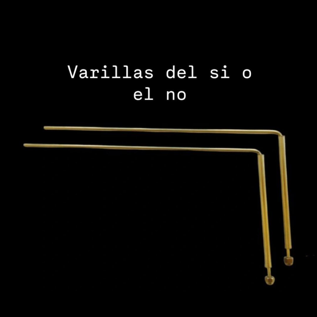 Dos varitas mágicas de color dorado, una horizontal y otra vertical, sobre un fondo negro.