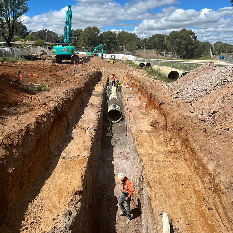 A construction site with pipes being installed in the dirt