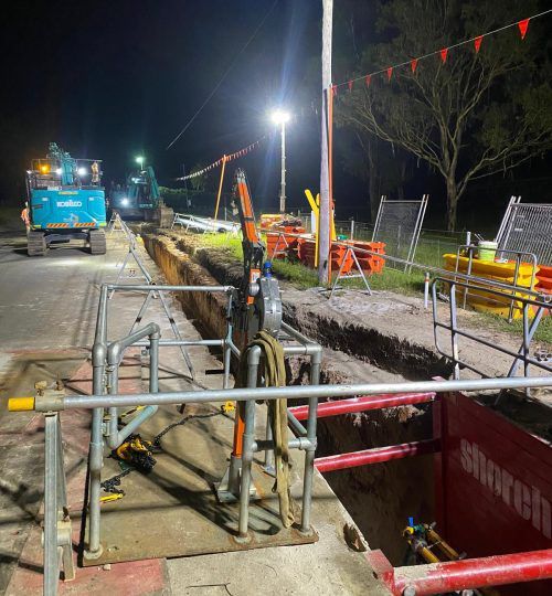 A construction site at night with a fence and a crane