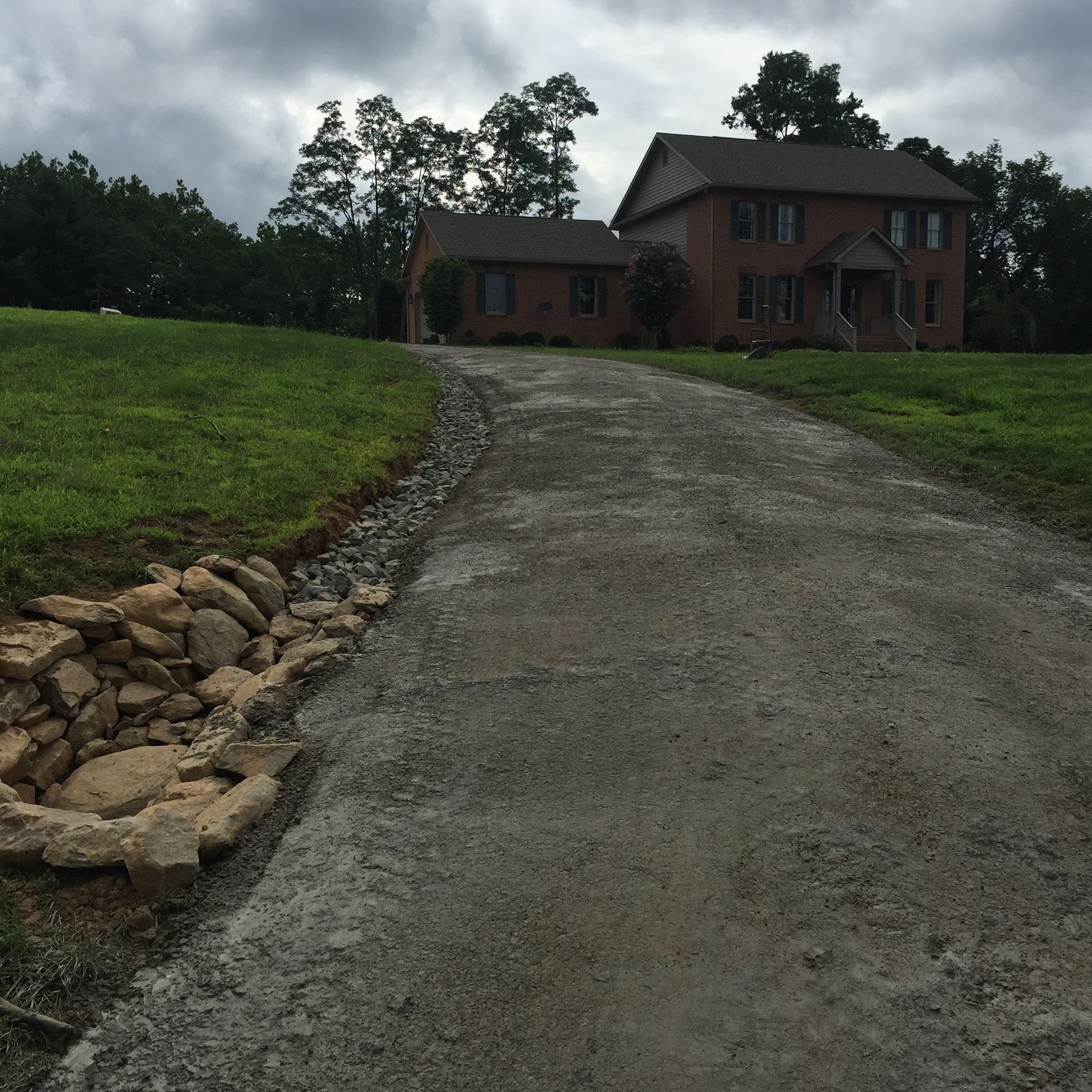 A dirt road leads to a large brick house
