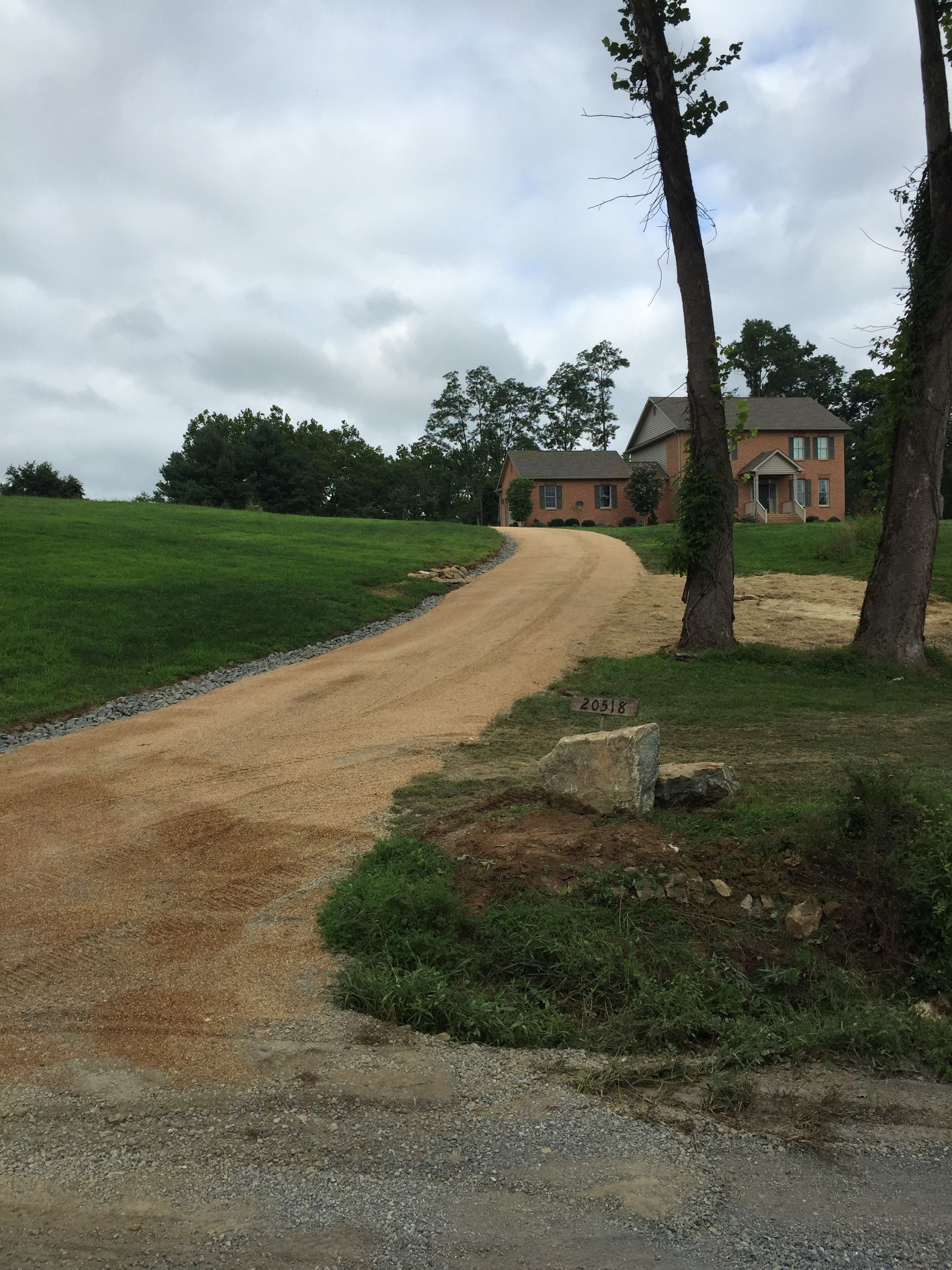 A dirt road leading to a house on a hill