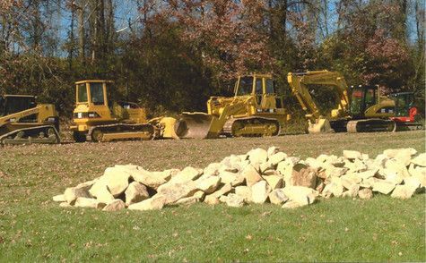 A group of construction vehicles are parked in a field.