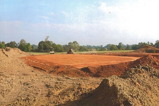 A large pile of dirt is sitting in the middle of a field.