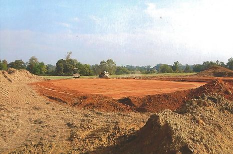 A large pile of dirt is in the middle of a field