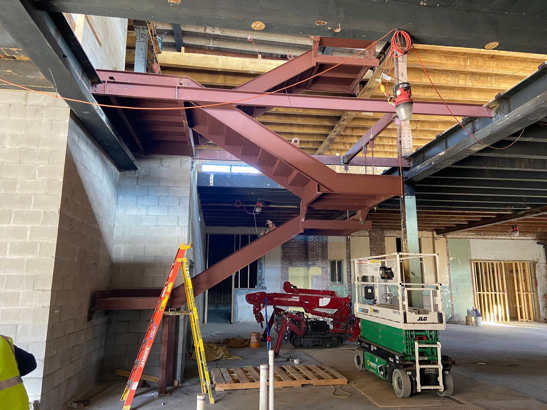 Metal awning structure with vertical beams; construction site.