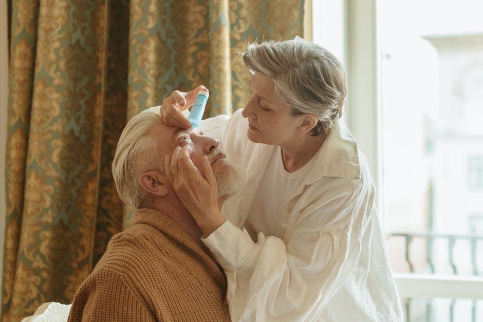 Image of spouse instilling eyedrops for  her husband