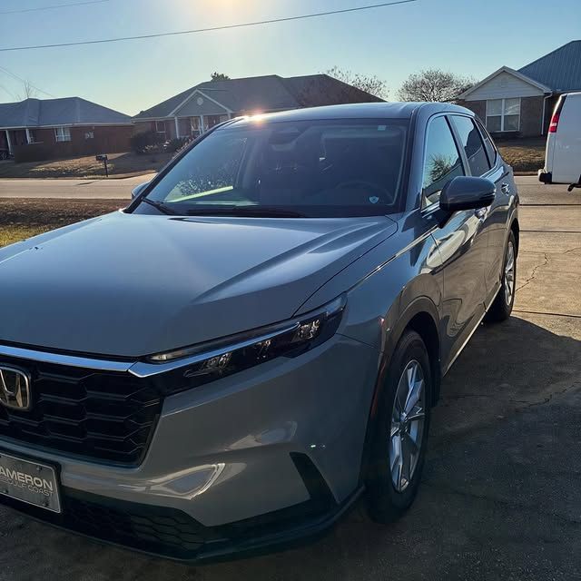 A gray Honda CR-V parked in a driveway on a sunny day.