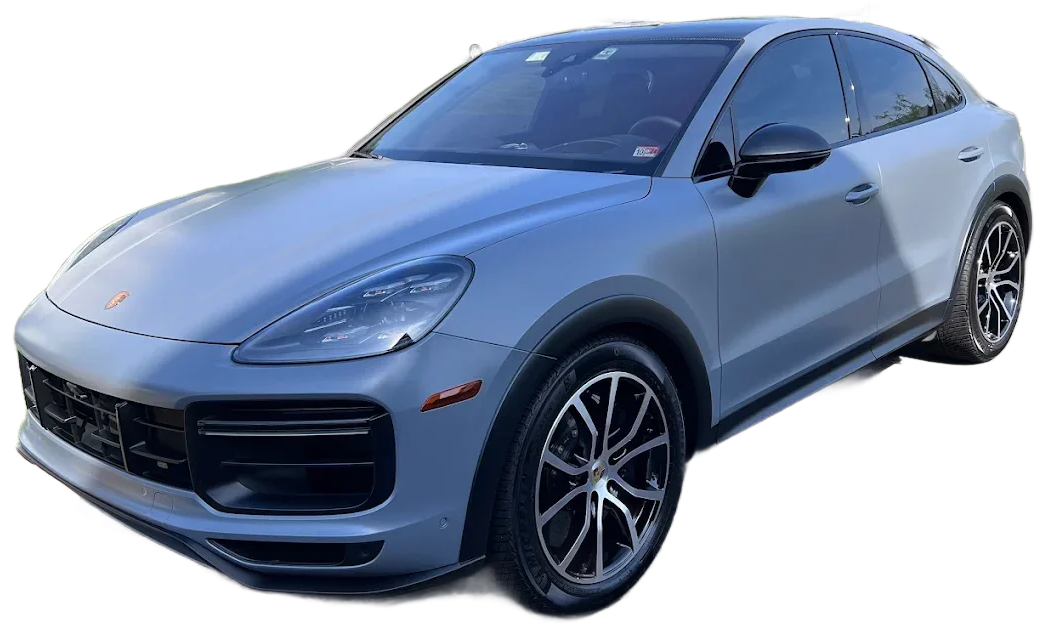 A matte blue Porsche Cayenne SUV viewed from the front three-quarter angle against a white background.