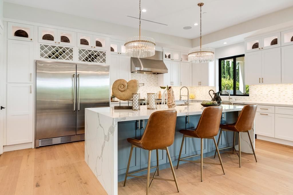 Modern kitchen with island, stainless steel appliances, and wood floors.