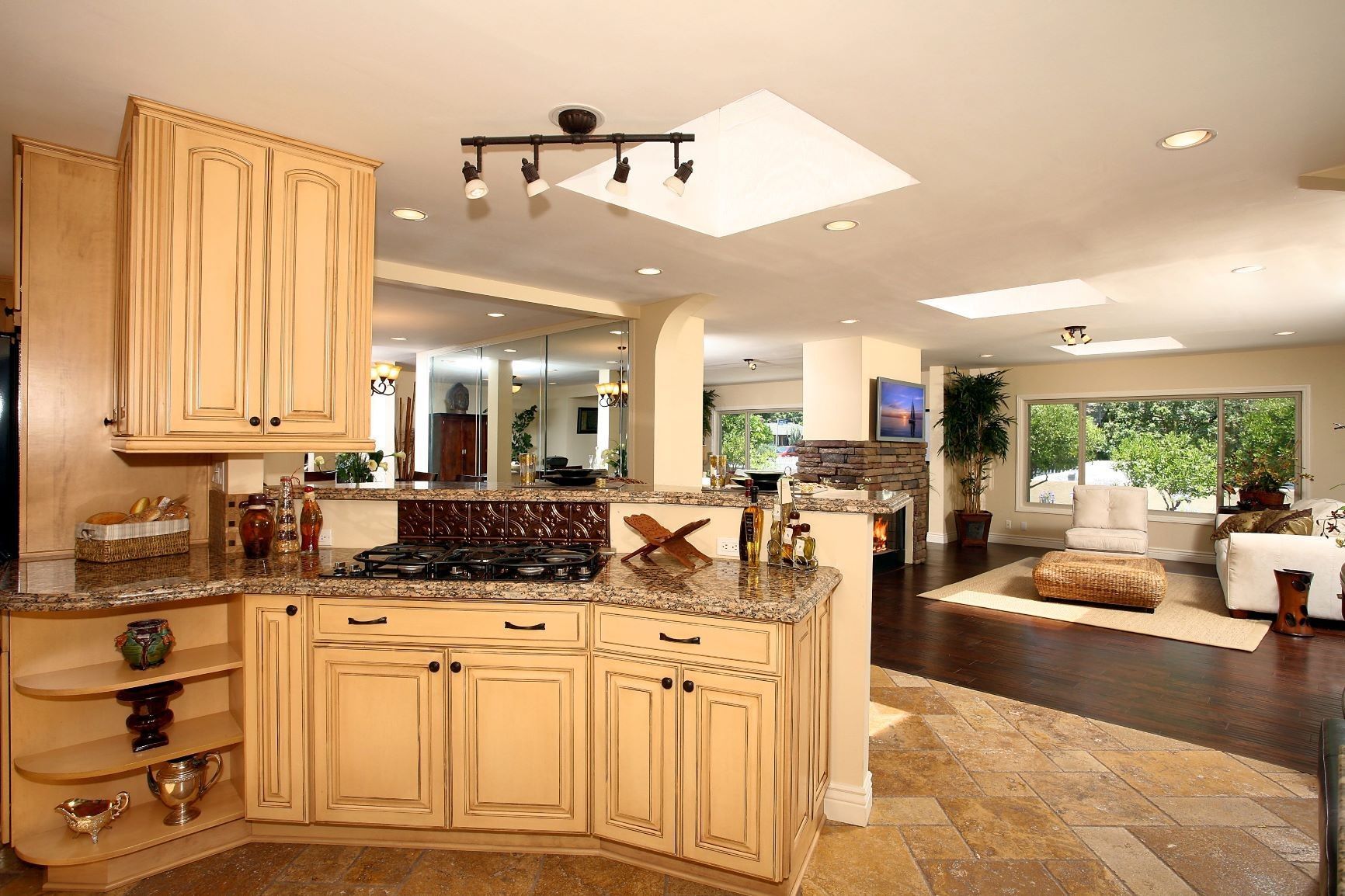 Kitchen with light-colored cabinets, granite countertops, and open concept living area.
