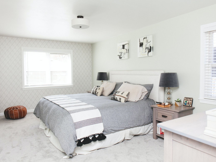 Bedroom with bed, nightstands, and window, neutral color scheme.