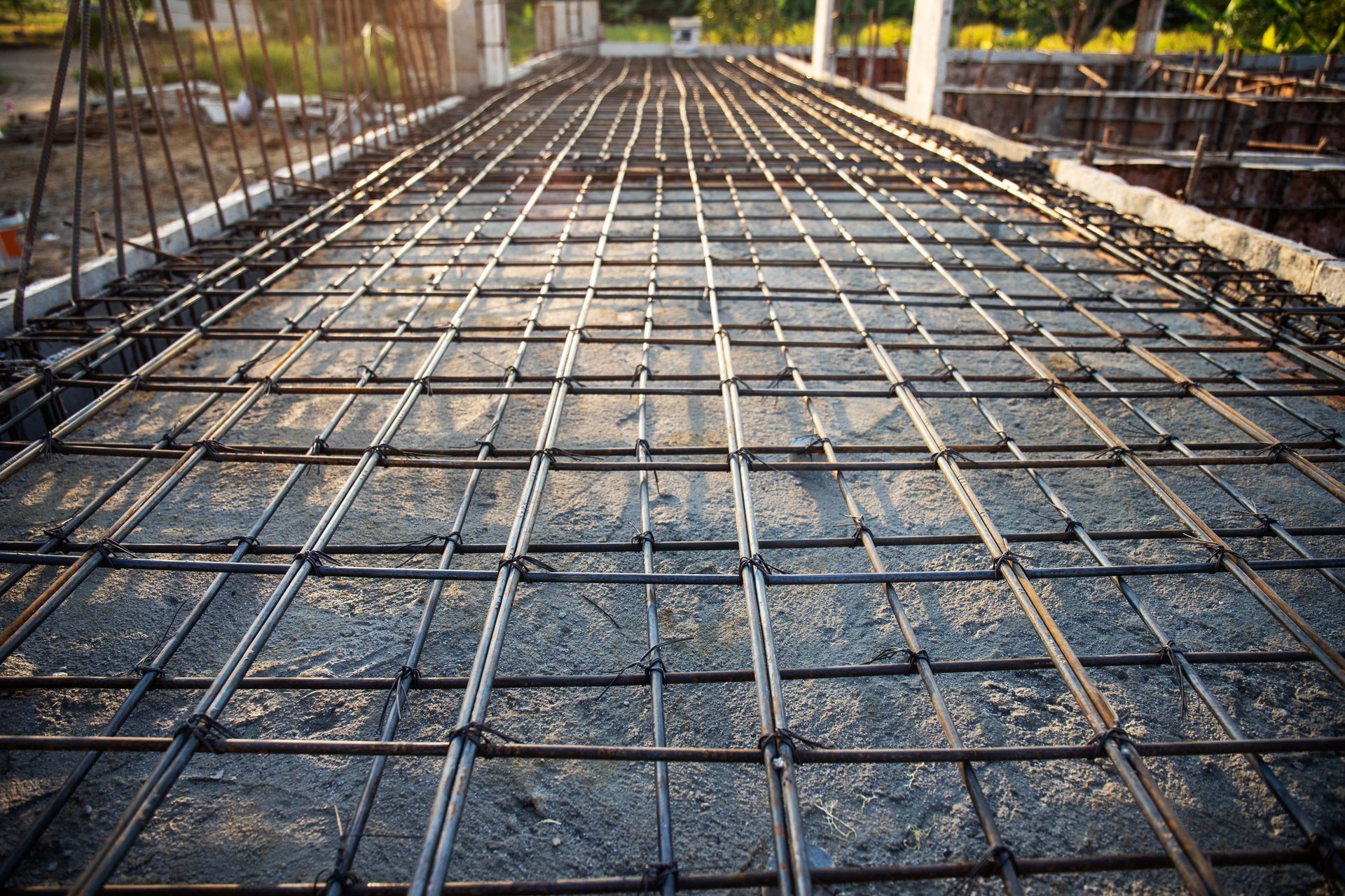 Reinforced steel bars grid laid on gravel bed for concrete foundation.