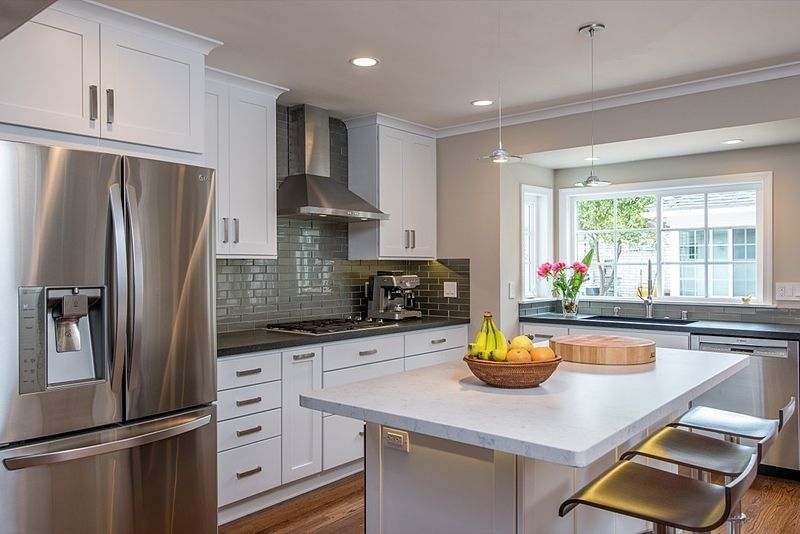Modern kitchen with white cabinets, stainless steel appliances, and a central island.