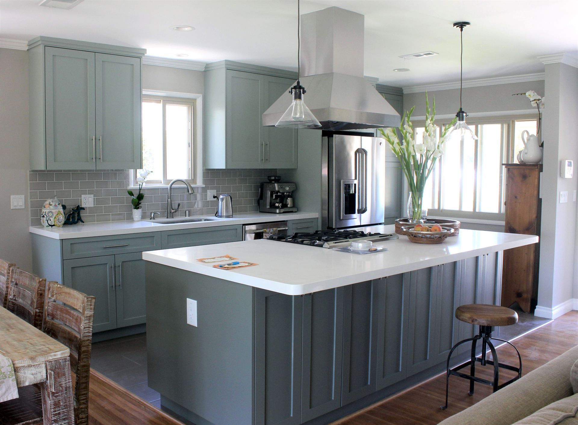 Modern kitchen with gray cabinets, white countertops, and stainless steel appliances.
