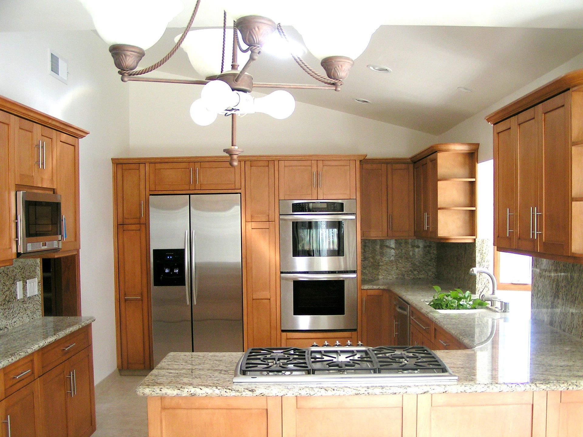 Kitchen with wooden cabinets, stainless steel appliances, and granite countertops.