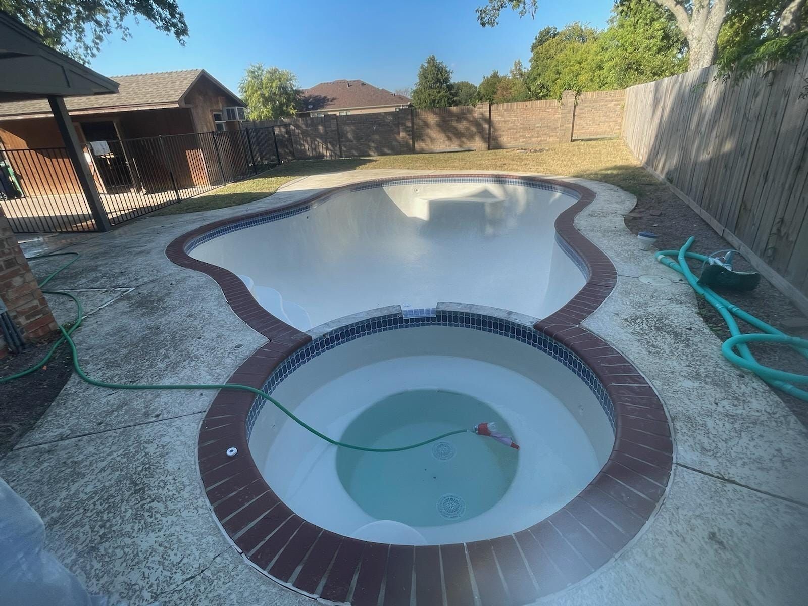 A swimming pool with a hot tub in the middle of it