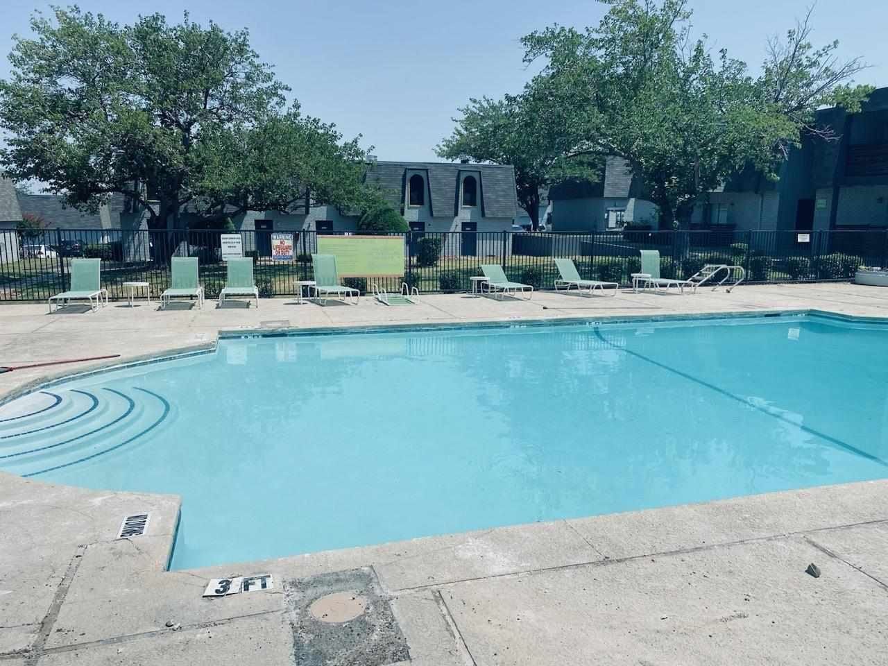 A large swimming pool with a lot of chairs around it