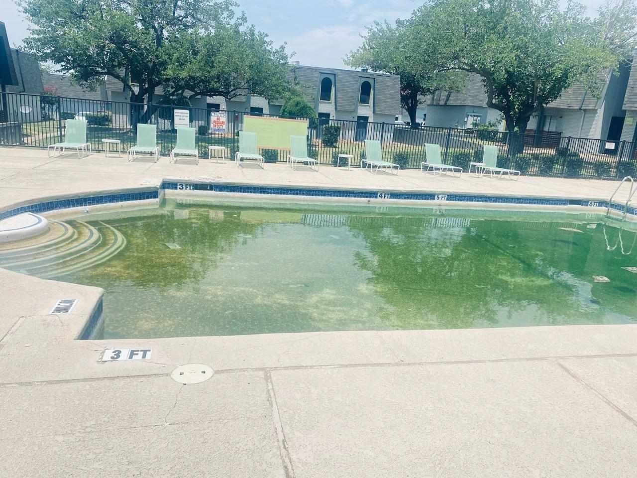 A swimming pool with a lot of chairs around it